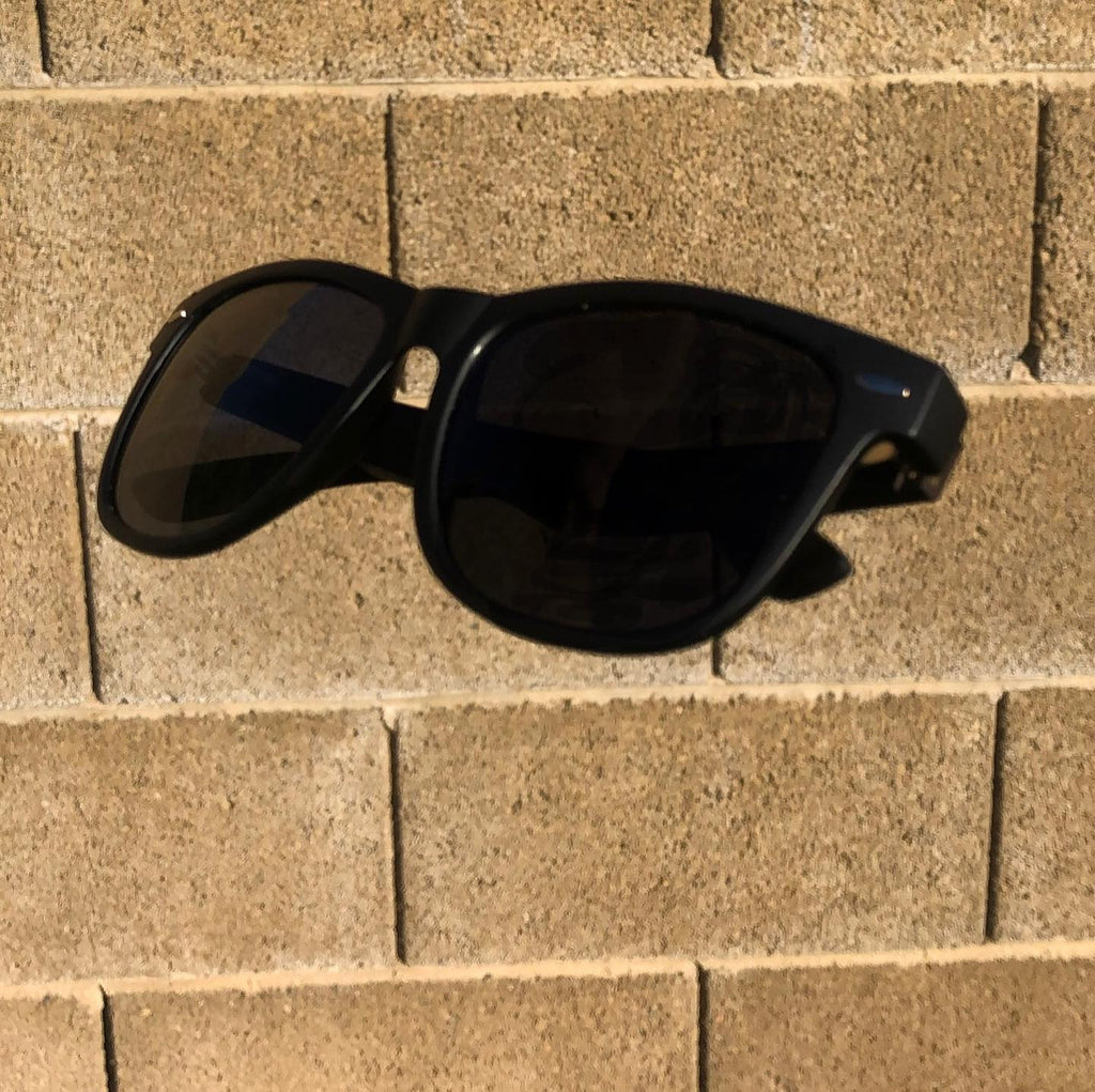 Hidden Rayz The Original polarized sunglasses resting on a block wall